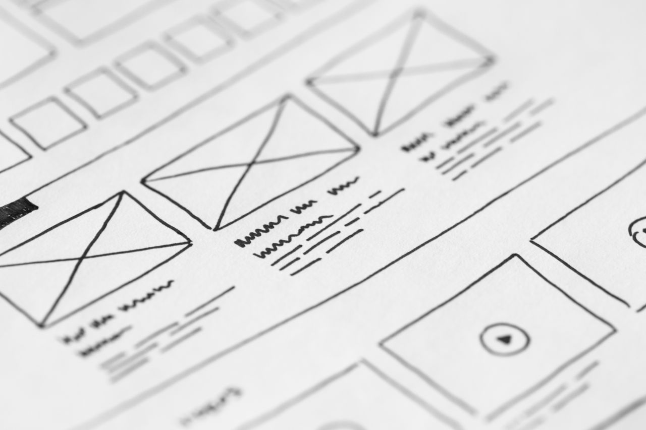 about-us-02 Detailed close-up of a hand-drawn wireframe design on paper for a UX project.